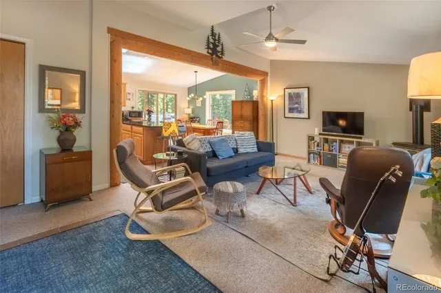 a living room with furniture a flat screen tv and floor to ceiling window
