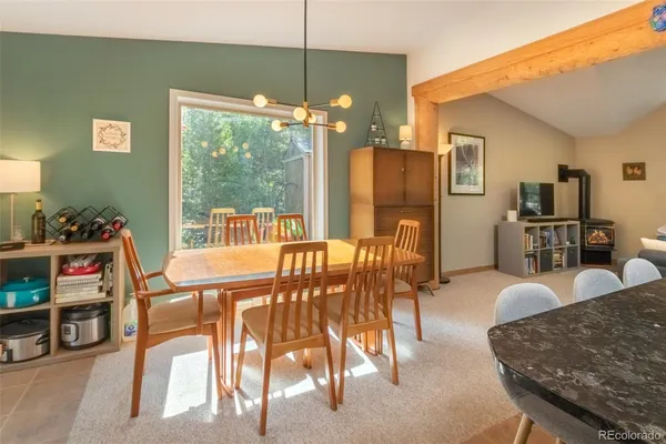 a view of a dining room with furniture a chandelier and large windows