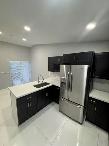 a kitchen with a refrigerator sink and cabinets