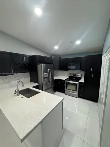 a kitchen with stainless steel appliances a refrigerator sink and stove