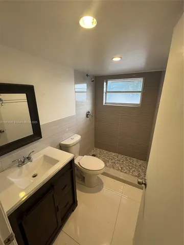 a bathroom with a sink a toilet a mirror and vanity