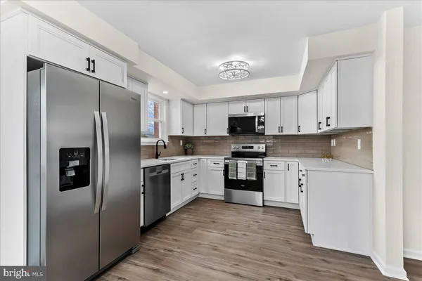 a kitchen with white cabinets stainless steel appliances and sink