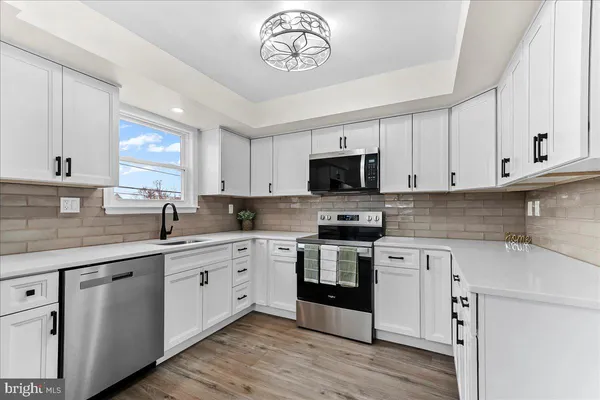 a kitchen with a sink cabinets stainless steel appliances and a window