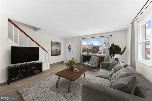 a living room with furniture a flat screen tv and a window