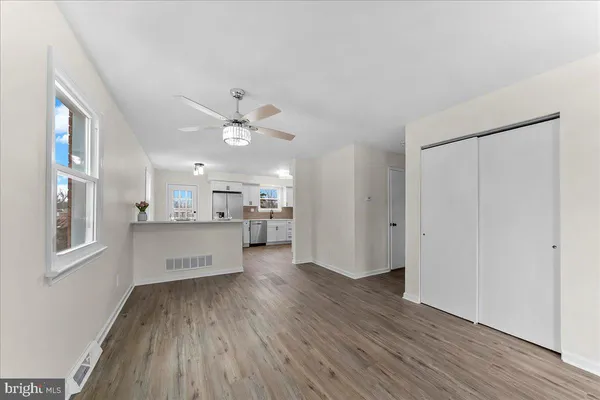 a view of a kitchen with wooden floor and a window
