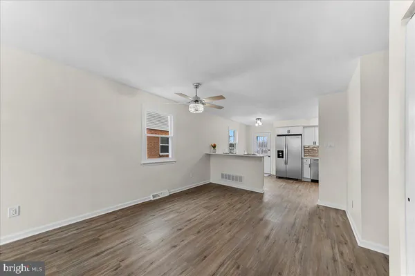 wooden floor in an empty room with a kitchen