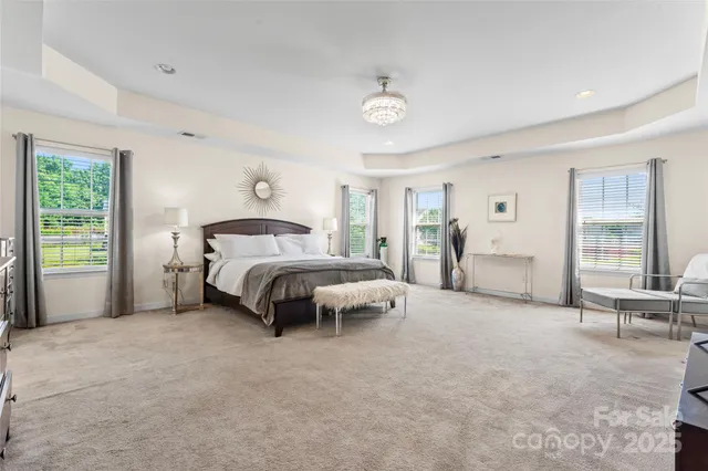 a spacious bedroom with a bed and large windows