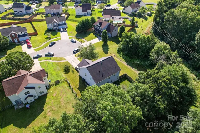 an aerial view of a house with swimming pool and outdoor seating