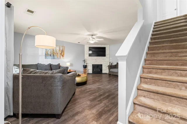 a living room with furniture a fireplace and a chandelier