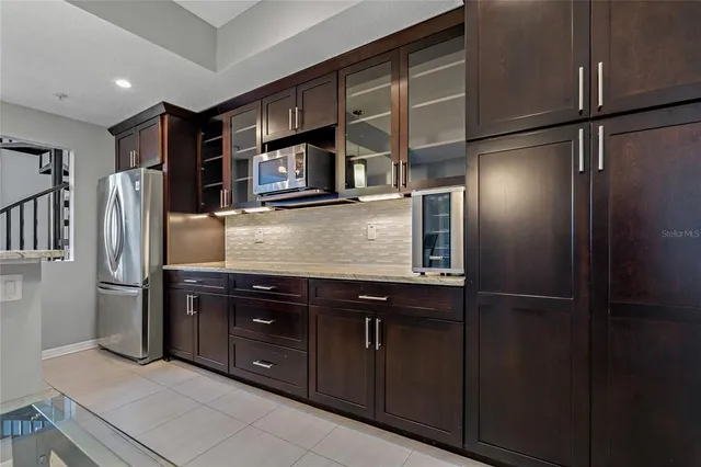 a kitchen with stainless steel appliances granite countertop a refrigerator and a sink