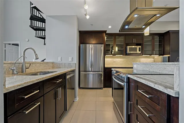 a kitchen with stainless steel appliances granite countertop a refrigerator and a stove