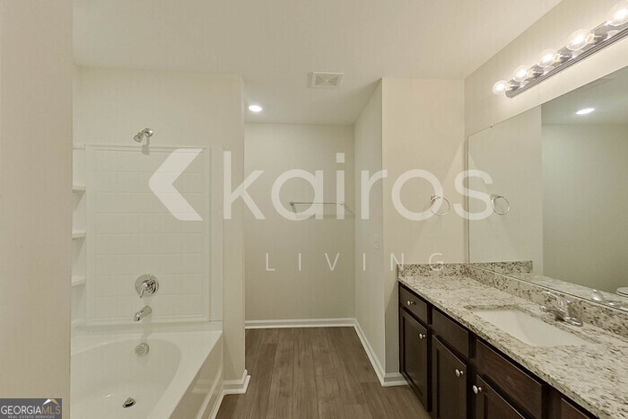 108 St Phillip Way Springfield, GA 31329 - Photo 22 of 29 a bathroom with a granite countertop sink a mirror and a bathtub