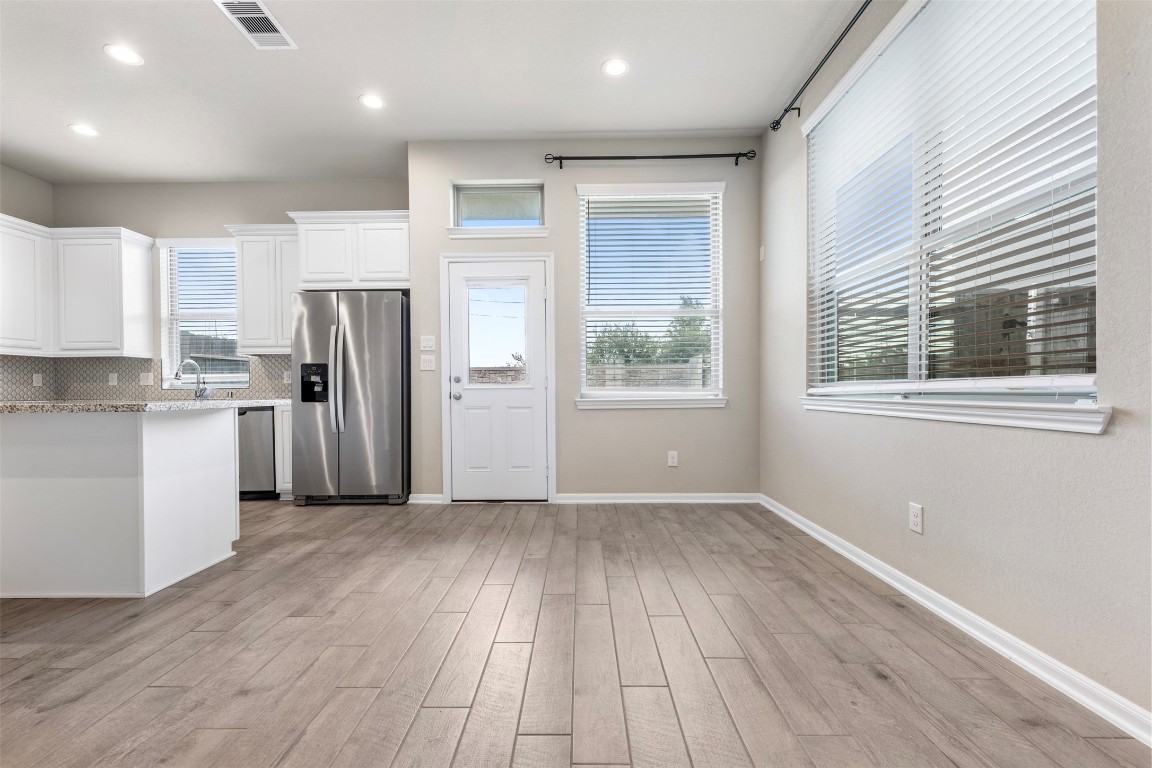 5203 Prairie Terrace Lane Fulshear, TX 77441 - Photo 4 of 32 a view of kitchen with stainless steel appliances wooden floor and a window