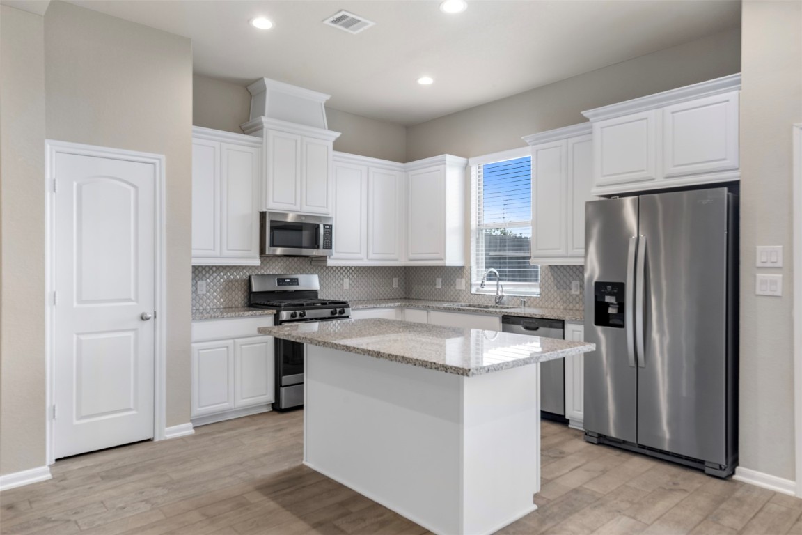 5203 Prairie Terrace Lane Fulshear, TX 77441 - Photo 8 of 32 a kitchen with stainless steel appliances granite countertop a refrigerator stove microwave and sink