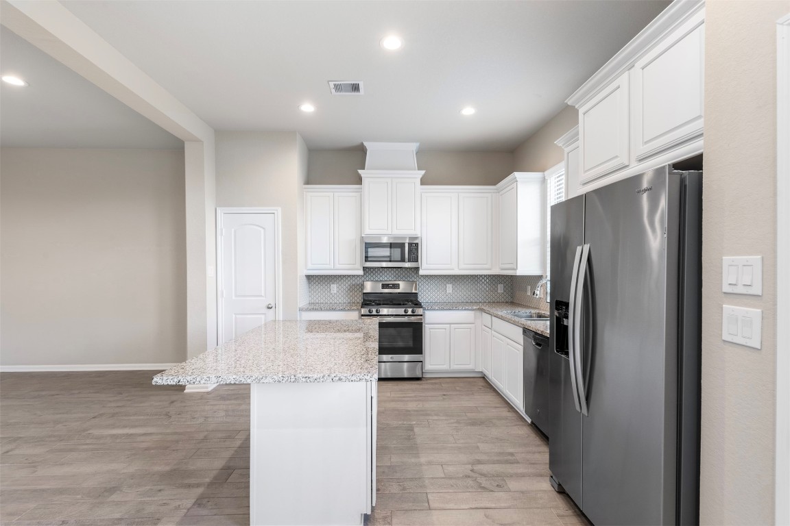 5203 Prairie Terrace Lane Fulshear, TX 77441 - Photo 10 of 32 a kitchen with stainless steel appliances granite countertop a refrigerator and a stove top oven