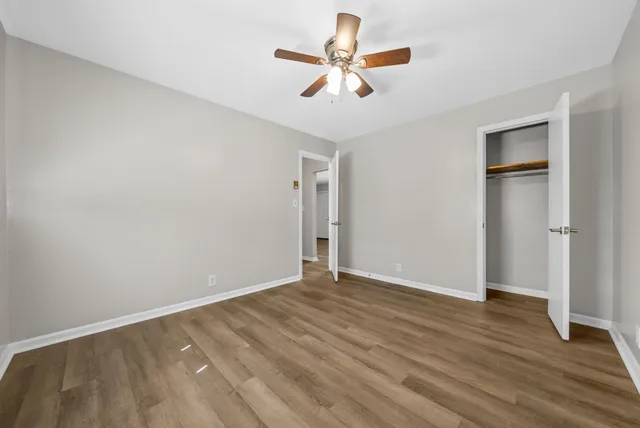 a view of room with wooden floor and ceiling fan