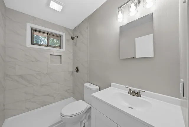 a bathroom with a toilet a sink and mirror