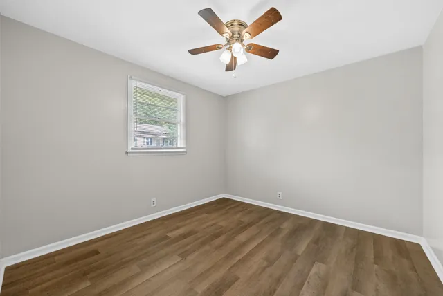 an empty room with a window and a fan