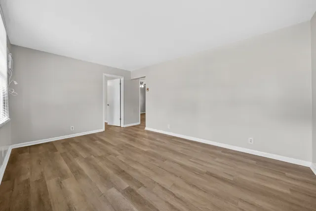 a view of an empty room with wooden floor