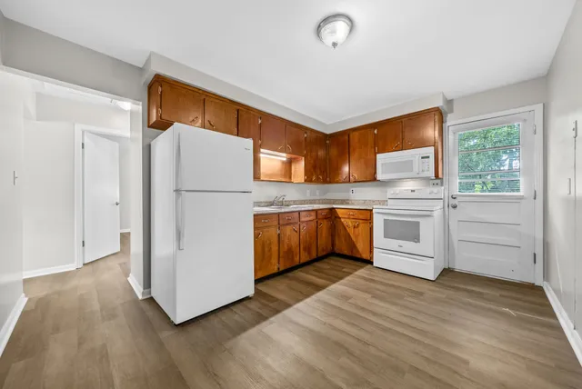 a kitchen with white cabinets and white appliances