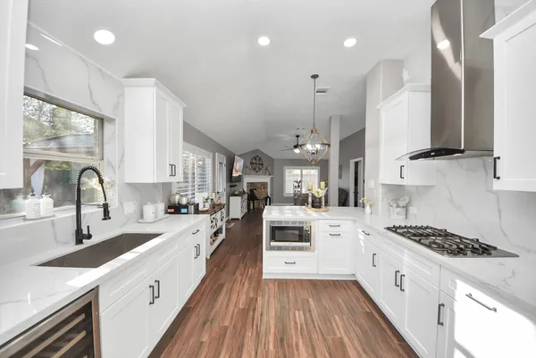 a large kitchen with stainless steel appliances sink a stove and cabinets
