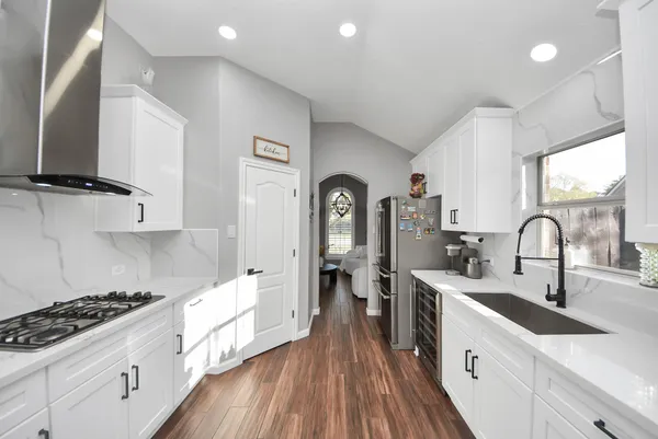 a large kitchen with stainless steel appliances granite countertop a lot of counter space and wooden floors