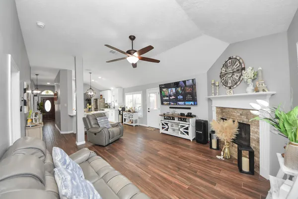 a living room with furniture a fireplace and wooden floor