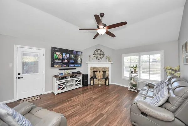 a living room with furniture and a wooden floor