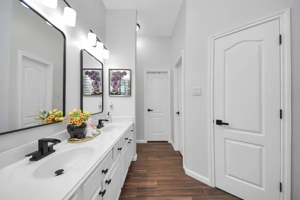 a spacious en suite bathroom with a double vanity sink and a large mirror