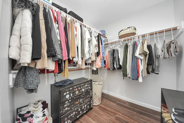 a view of walk in closet with clothes