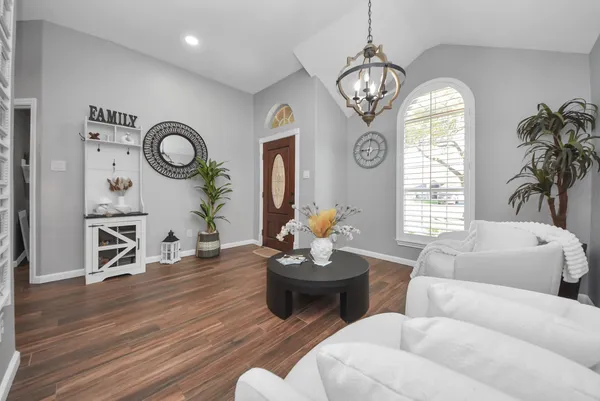 a living room with furniture a window and a chandelier