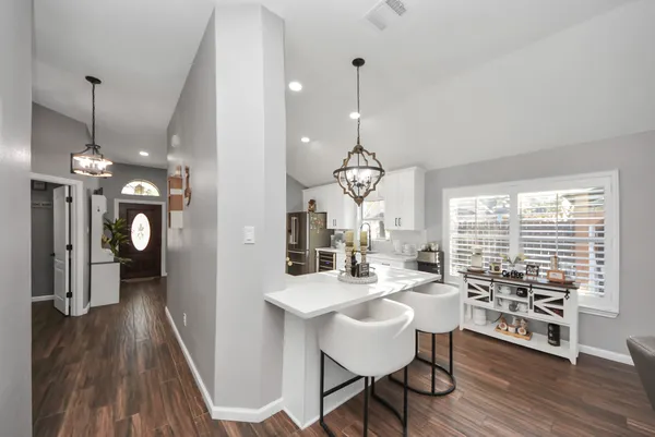 a view of a dining room and livingroom with furniture wooden floor a chandelier
