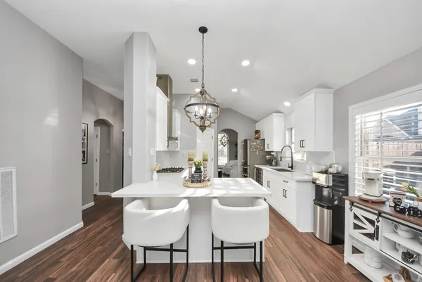 a large kitchen with a table and chairs