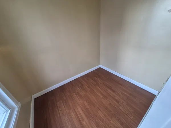 a view of an empty room with wooden floor