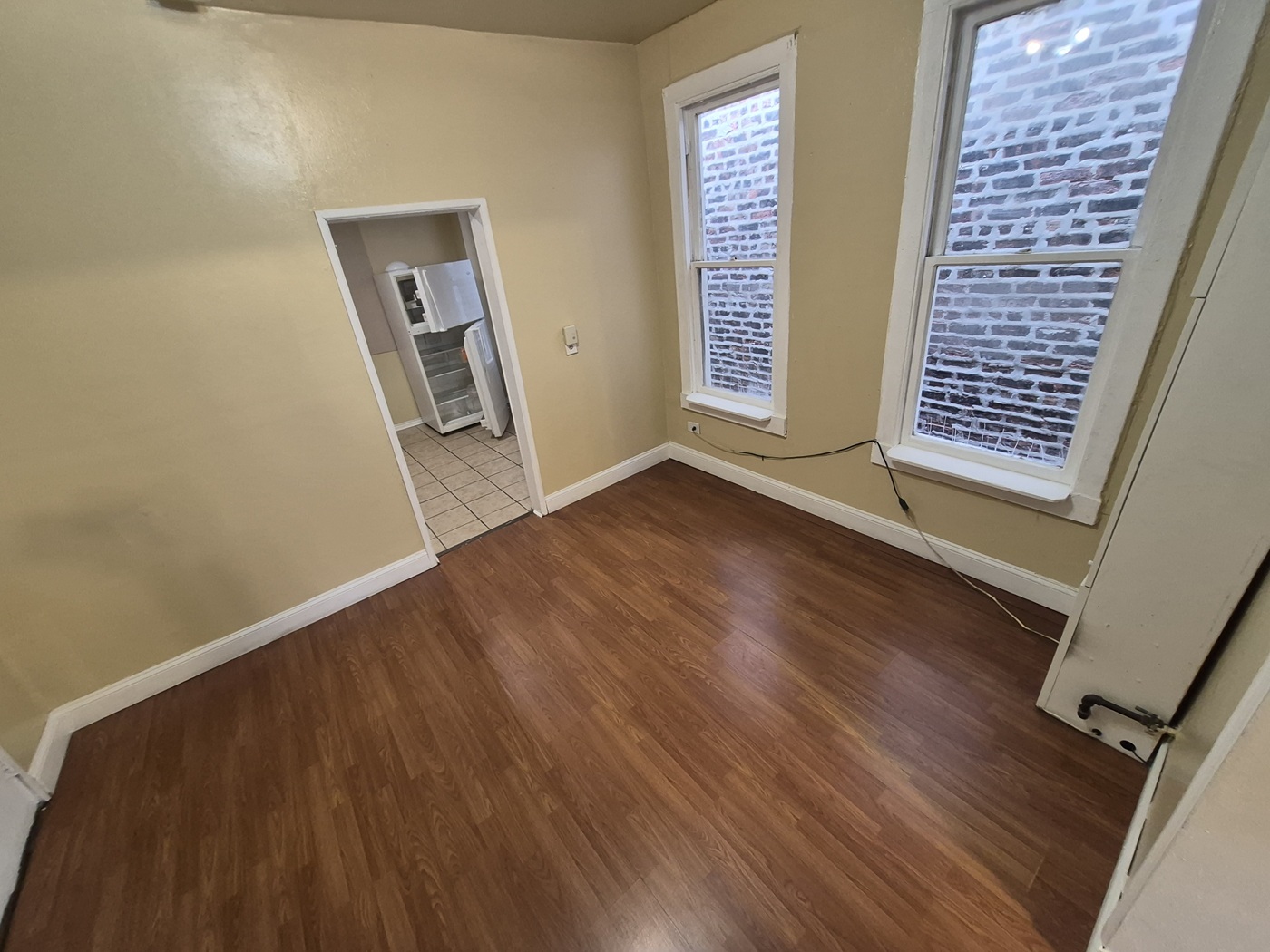 2046 West 19th Street, Unit 2 Chicago, IL 60608 - Photo 5 of 11 an empty room with wooden floor and windows