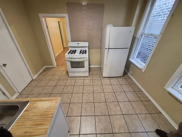 a view of kitchen with microwave and refrigerator
