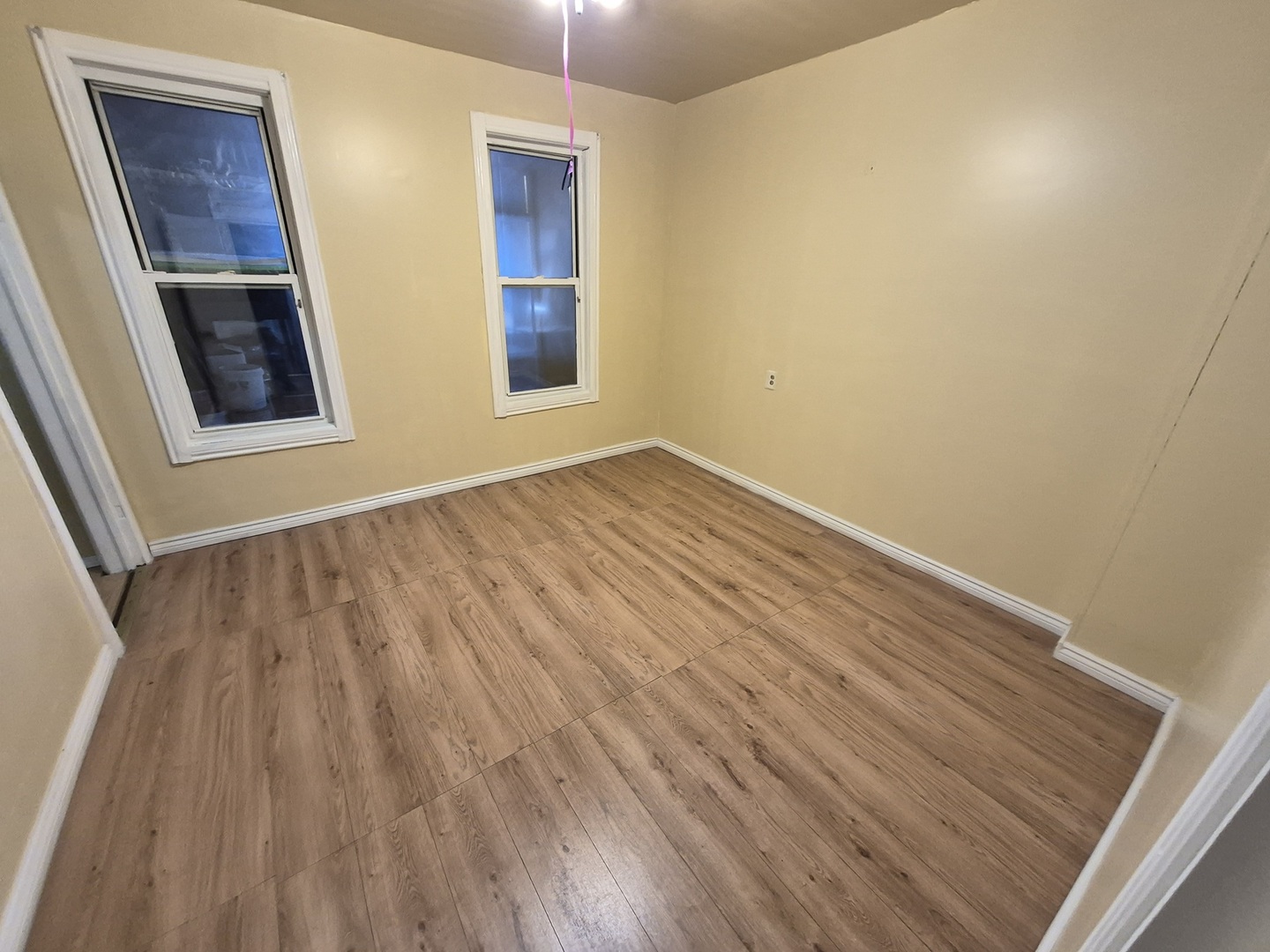 2046 West 19th Street, Unit 2 Chicago, IL 60608 - Photo 10 of 11 an empty room with wooden floor and windows