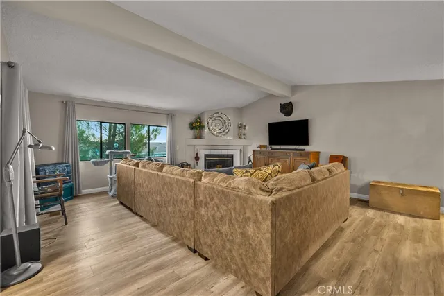 a living room with furniture a fireplace and a flat screen tv