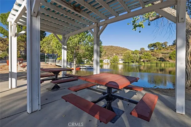 a view of swimming pool with seating area and trees in the background