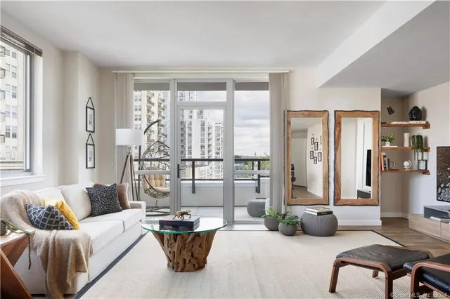 a kitchen with stainless steel appliances a stove a sink a refrigerator white cabinets and wooden floor