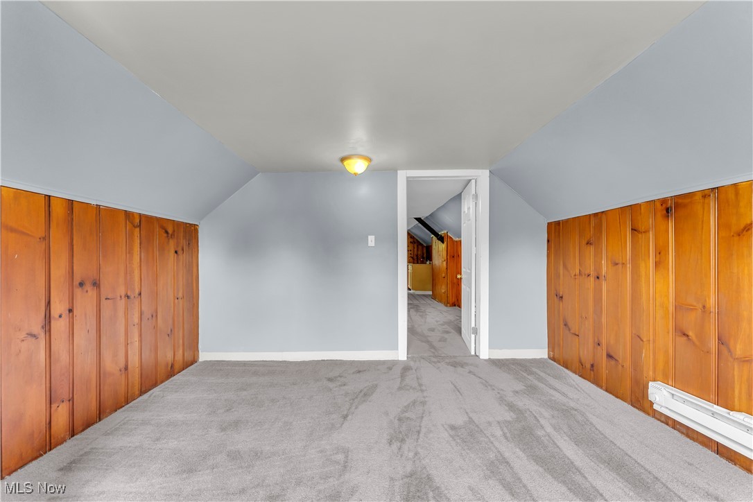 913 Helmsdale Road, Unit 3 Cleveland, OH 44112 - Photo 11 of 19 Additional living space with wood walls, carpet floors, baseboard heating, and lofted ceiling