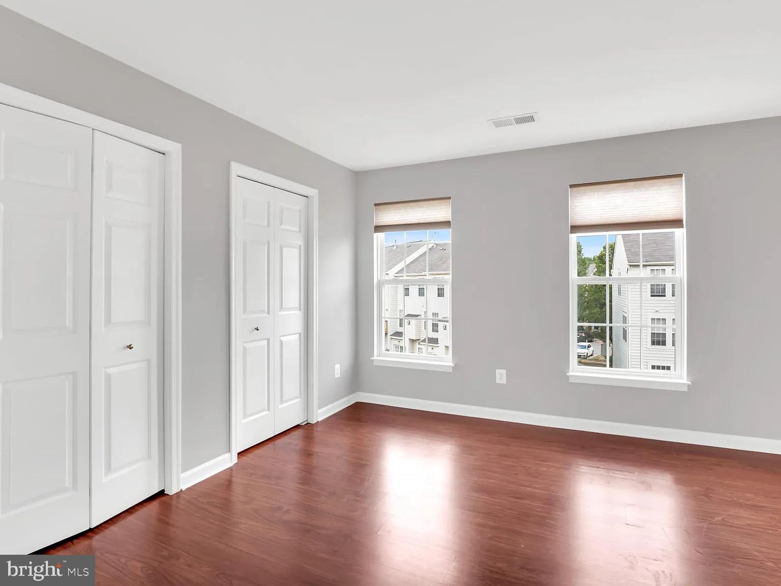 44480 Watertown Terrace Ashburn, VA 20147 - Photo 19 of 22 an empty room with wooden floor and windows
