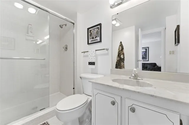 a bathroom with a granite countertop sink toilet and shower