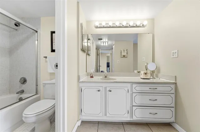 a bathroom with a granite countertop sink a toilet and a mirror