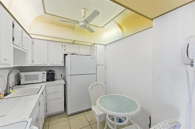 a kitchen with a refrigerator sink and cabinets