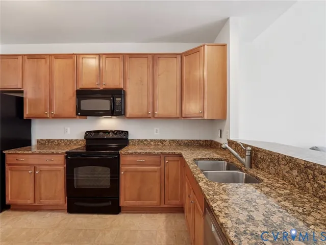 a kitchen with granite countertop a sink stove and cabinets