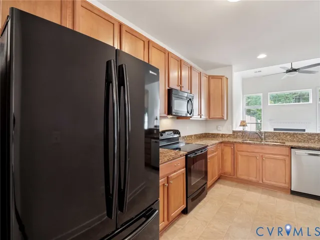 a kitchen with stainless steel appliances granite countertop a refrigerator and a sink