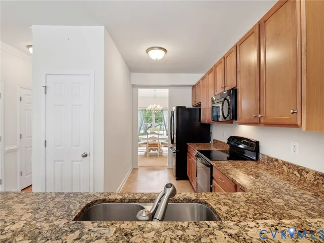 a kitchen with stainless steel appliances granite countertop a sink refrigerator and cabinets