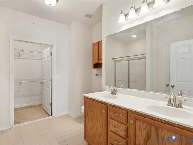 a bathroom with double vanity sink and a mirror