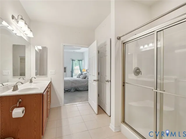 a en suite bathroom with a shower sink and mirror